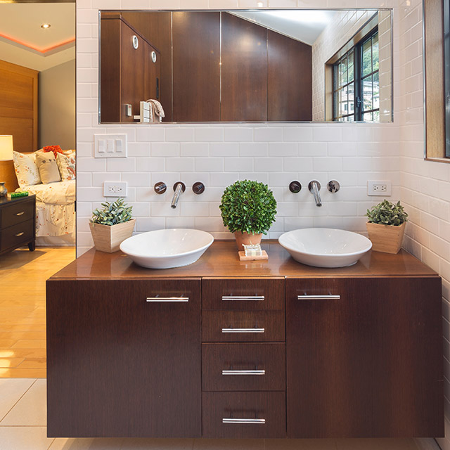 Custom bathroom vanity with dark wood cabinets, double vessel sinks, and modern design by Total 3D Cabinets in Austin, TX.